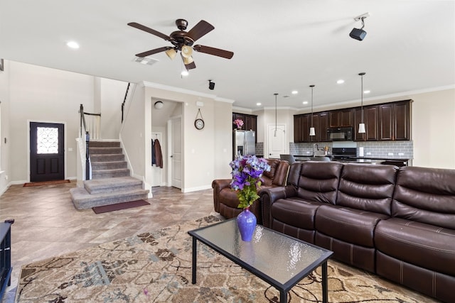 living room featuring crown molding, sink, and ceiling fan