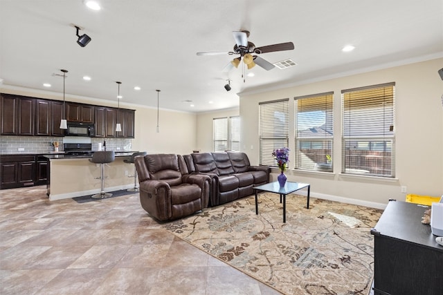 living room with ceiling fan and crown molding