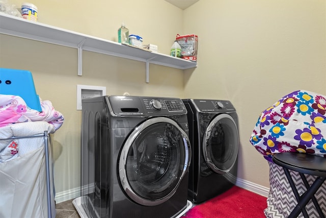 laundry area featuring dark tile patterned flooring and washer and dryer