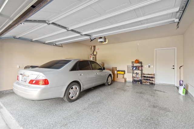 garage featuring strapped water heater and a garage door opener