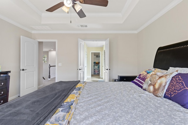 carpeted bedroom with a raised ceiling, ceiling fan, and crown molding