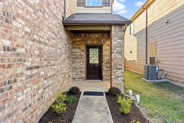 entrance to property featuring central air condition unit and a yard