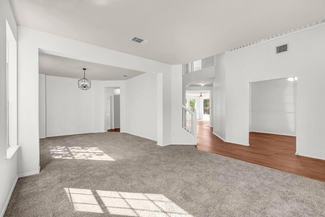 spare room with a notable chandelier and carpet flooring