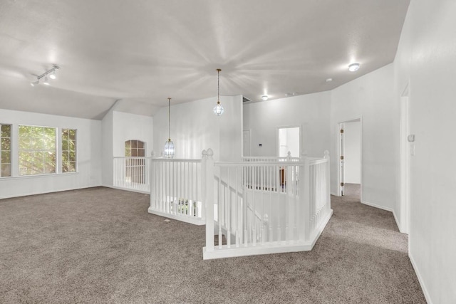 carpeted empty room featuring lofted ceiling