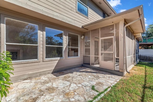 view of home's exterior featuring a sunroom and a patio