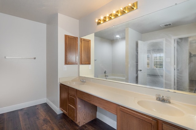 bathroom with hardwood / wood-style floors, vanity, and a bath