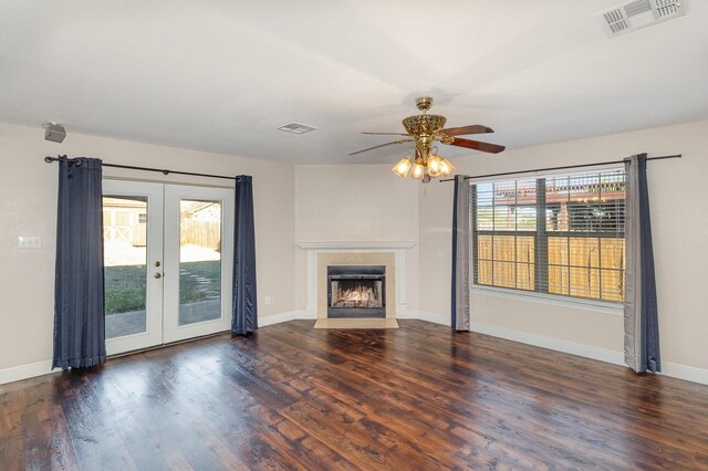 unfurnished living room featuring plenty of natural light, ceiling fan, dark hardwood / wood-style flooring, and french doors