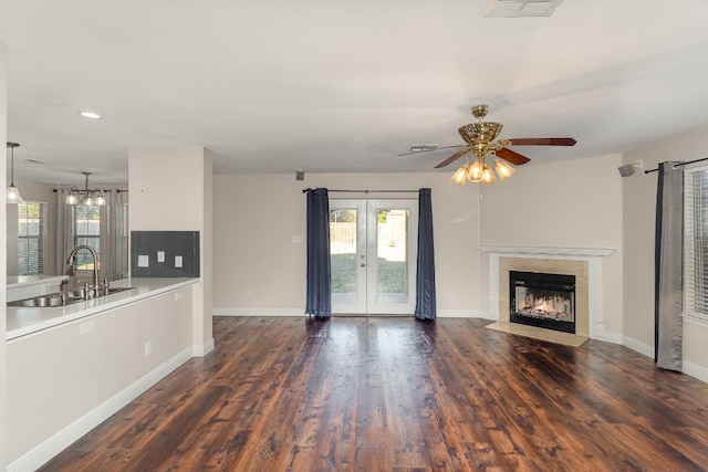 unfurnished living room with ceiling fan, dark hardwood / wood-style flooring, french doors, and sink