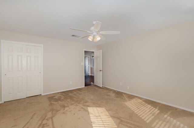 unfurnished bedroom with ceiling fan, a closet, and light colored carpet