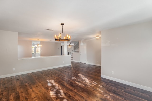 unfurnished room with dark wood-type flooring and a notable chandelier