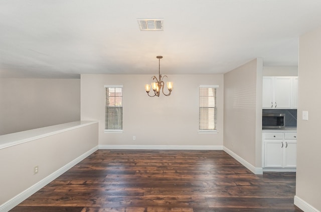 interior space featuring dark hardwood / wood-style flooring, plenty of natural light, and an inviting chandelier