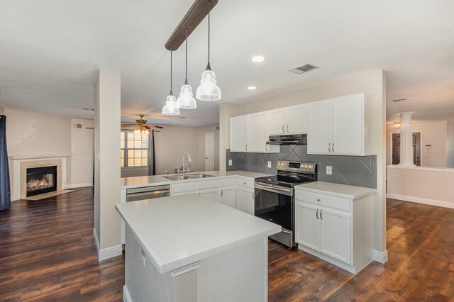 kitchen with ceiling fan, sink, stainless steel appliances, dark wood-type flooring, and kitchen peninsula