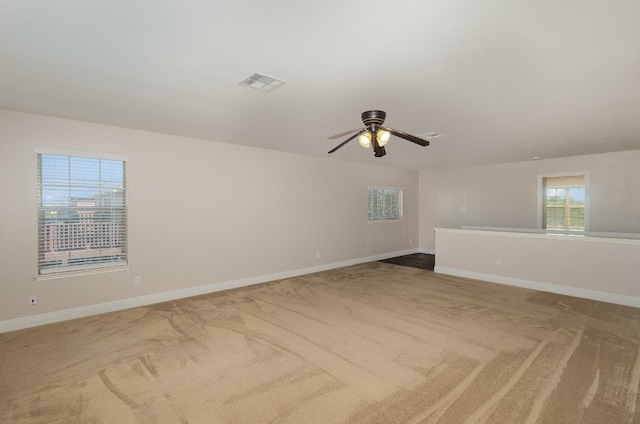 carpeted spare room featuring ceiling fan