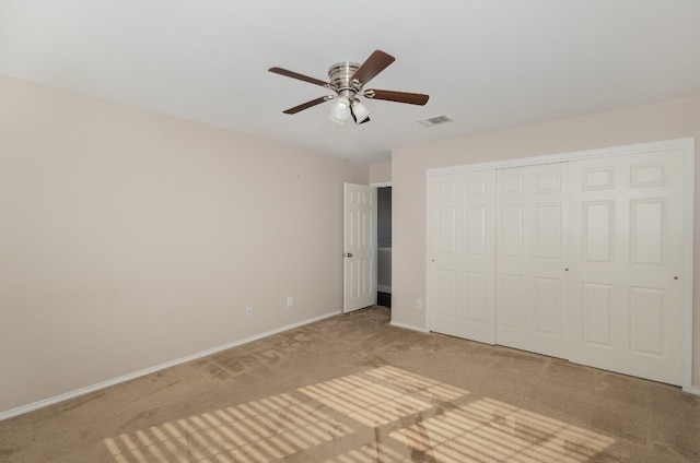 unfurnished bedroom with ceiling fan, carpet floors, and a closet