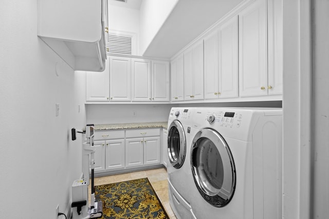 laundry area featuring light tile patterned flooring, cabinets, and independent washer and dryer