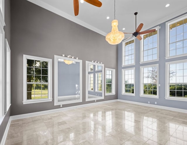 unfurnished sunroom with ceiling fan with notable chandelier