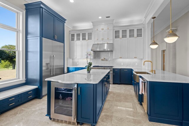 kitchen with wine cooler, premium appliances, sink, decorative light fixtures, and white cabinetry