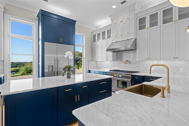 kitchen featuring a wealth of natural light, white cabinets, extractor fan, and high end appliances