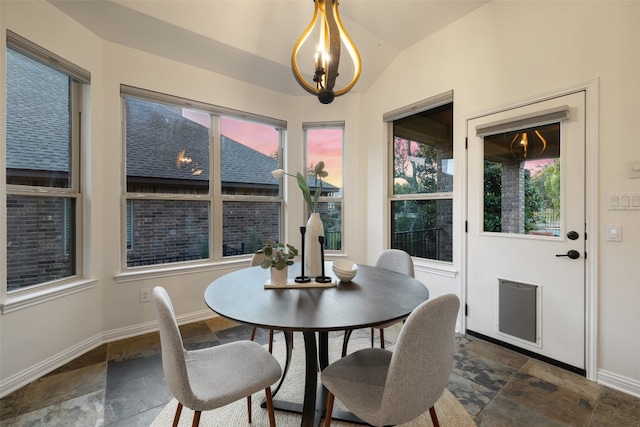 dining area with a chandelier and vaulted ceiling