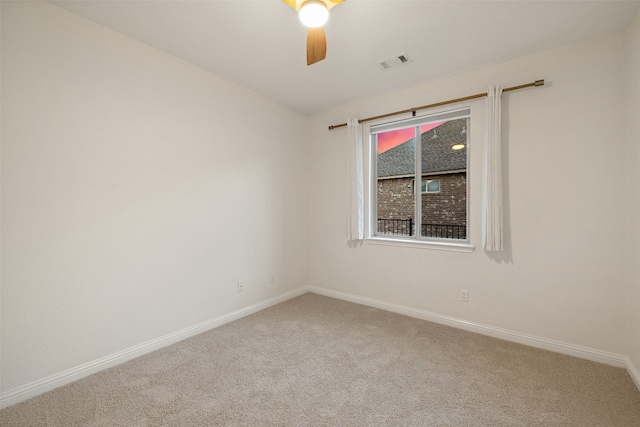 carpeted spare room featuring ceiling fan