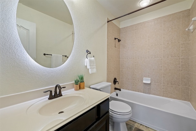 full bathroom featuring vanity, tiled shower / bath combo, and toilet