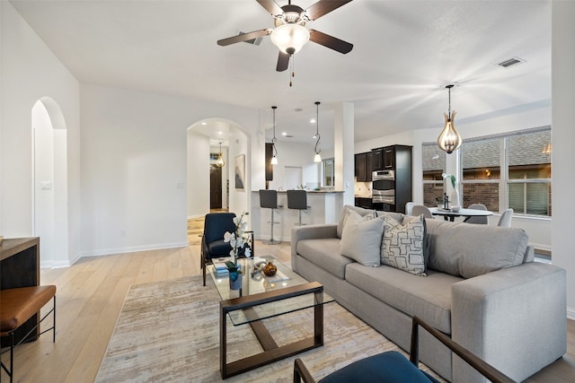 living room with ceiling fan and light wood-type flooring