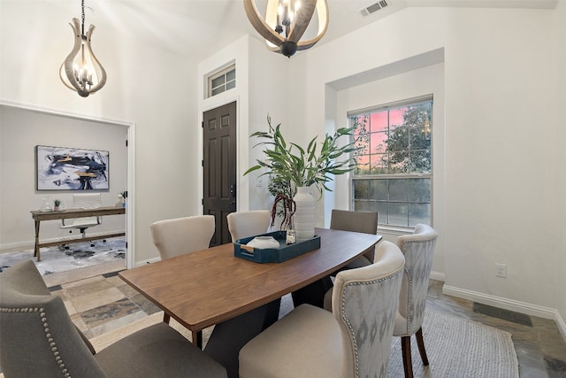 dining space with lofted ceiling and an inviting chandelier