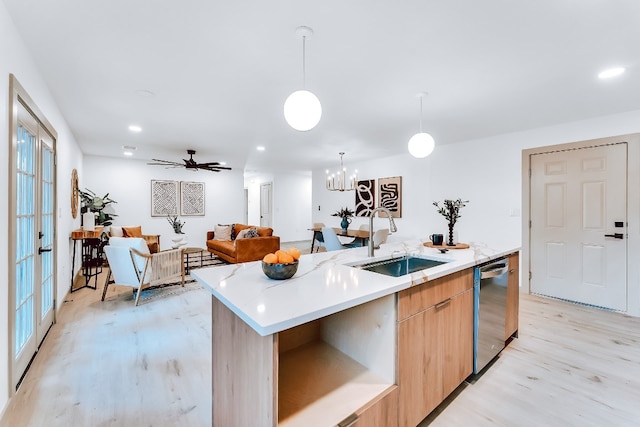 kitchen with stainless steel dishwasher, a healthy amount of sunlight, sink, and a kitchen island with sink