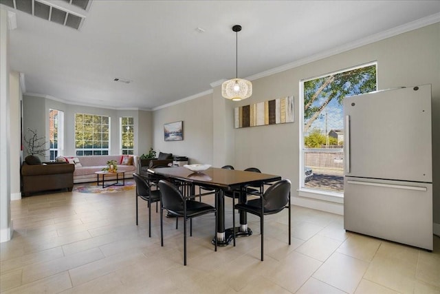 dining space featuring crown molding