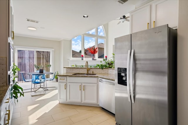 kitchen with stainless steel appliances, crown molding, sink, stone countertops, and white cabinetry