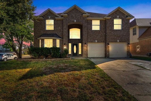 view of front of property featuring a lawn and a garage