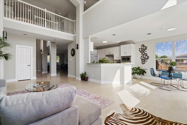 tiled living room featuring a towering ceiling