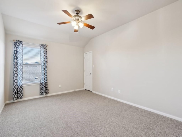 empty room with vaulted ceiling, carpet, and ceiling fan