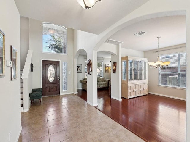 tiled foyer with a chandelier