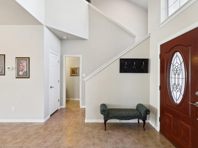 tiled entrance foyer with a healthy amount of sunlight and a high ceiling