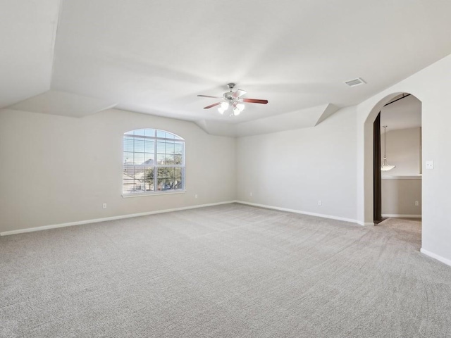 carpeted spare room featuring vaulted ceiling and ceiling fan