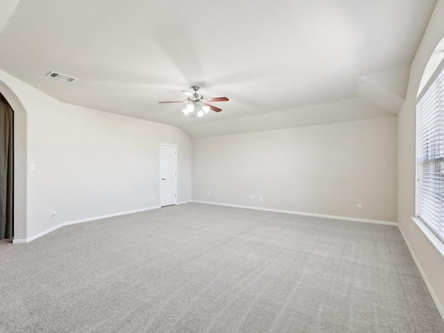 empty room with ceiling fan, carpet floors, a healthy amount of sunlight, and lofted ceiling