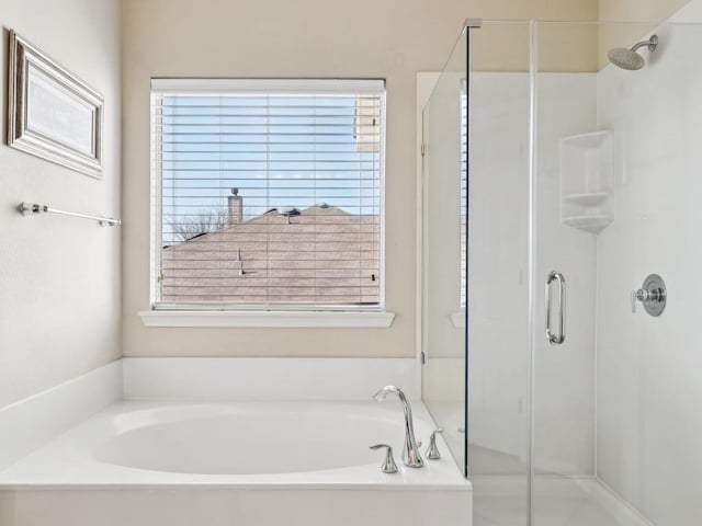 bathroom featuring shower with separate bathtub