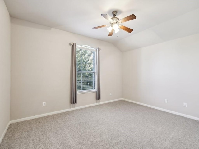 empty room featuring vaulted ceiling, ceiling fan, and carpet flooring