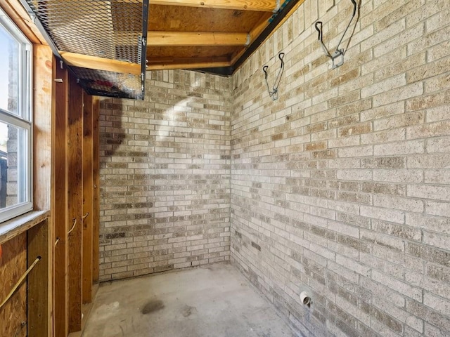 interior space featuring concrete flooring and brick wall