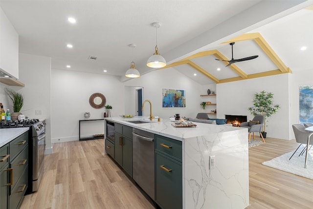 kitchen with stainless steel appliances, ceiling fan, a kitchen island with sink, sink, and lofted ceiling with beams