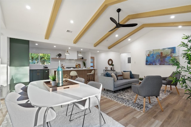 living room with vaulted ceiling with beams, ceiling fan, and light hardwood / wood-style floors