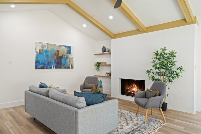 living room with vaulted ceiling with beams and light wood-type flooring