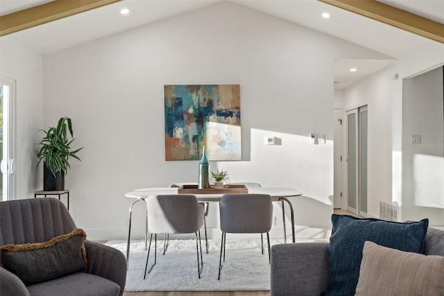 dining room featuring lofted ceiling with beams