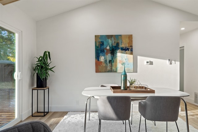 dining area with light hardwood / wood-style floors and lofted ceiling