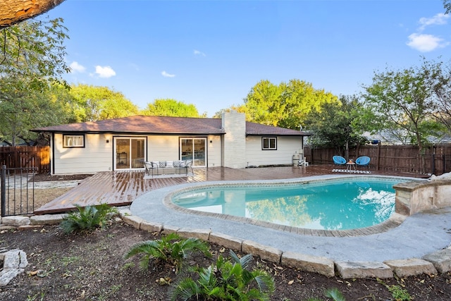 view of swimming pool with an outdoor living space and a wooden deck