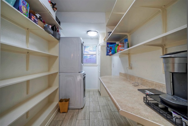 laundry room with stacked washer / drying machine and light wood-type flooring