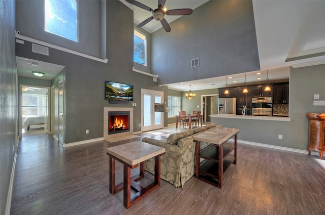 living room with dark hardwood / wood-style floors, a healthy amount of sunlight, and ceiling fan with notable chandelier