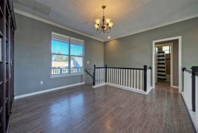 empty room featuring dark hardwood / wood-style flooring, an inviting chandelier, and crown molding