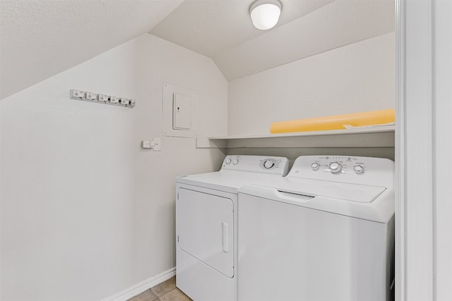 clothes washing area featuring washing machine and dryer, light tile patterned floors, and electric panel